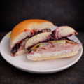 plain bagel sandwich with cream cheese egg turkey and blueberry jam