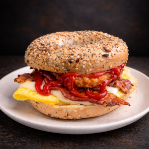 everything bagel sandwich with egg cheese bacon hash brown and ketchup